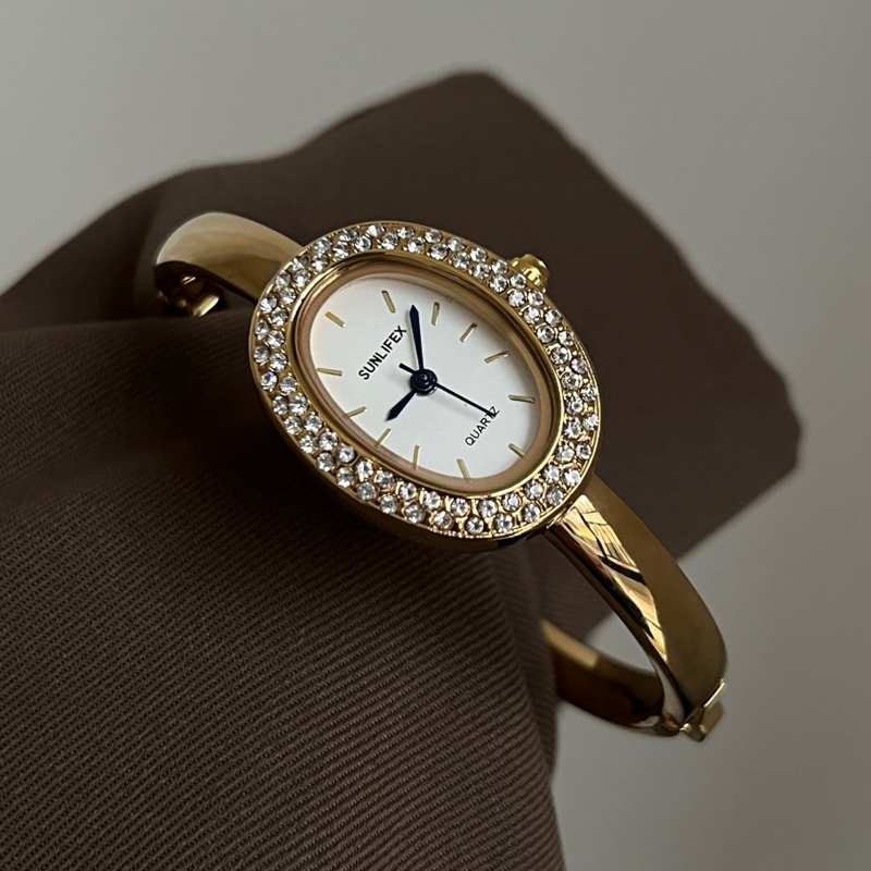 Relógio feminino dourado com bracelete rígido oval com cristal – mostrador branco elegante